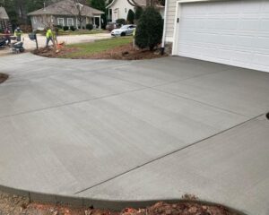 Freshly paved concrete driveway in residential area.