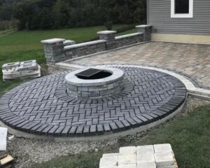 Outdoor patio with fire pit and stone architecture.