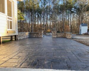 Stone patio with forest background and shed.