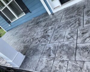 Stamped concrete patio with gray textured tiles.