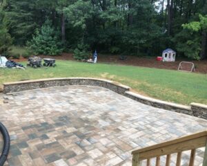 Backyard patio with stone pavers and play area.