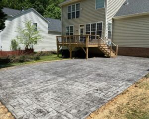 Backyard patio with wooden deck and stairs.