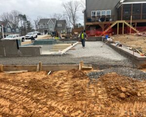 Construction site with unfinished pool and worker.