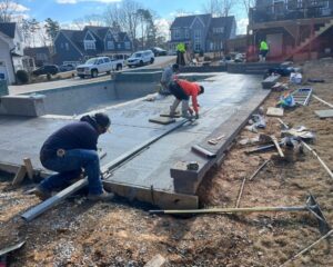 Workers constructing a swimming pool in suburban area.