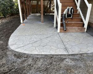 Stamped concrete patio with stairs and leaf blower.