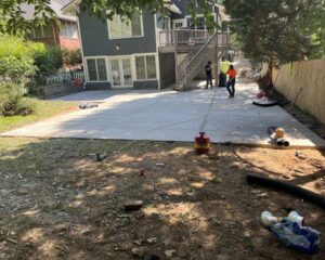 Construction workers on newly paved concrete driveway