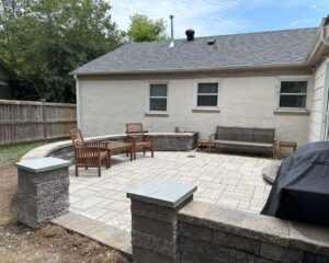 Backyard patio with seating and stone wall.