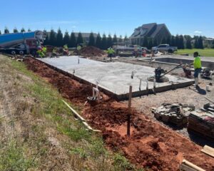 Workers pouring concrete for new house foundation.