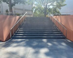 Concrete steps with railings and trees nearby.