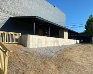 Industrial building with loading dock and gravel.