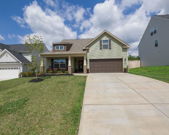 A home with two garages and a concrete driveway.