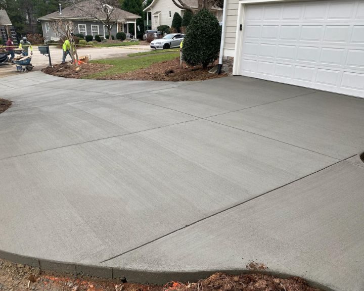 Freshly paved concrete driveway in residential area.