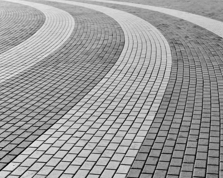 A black and white photo of a brick road.