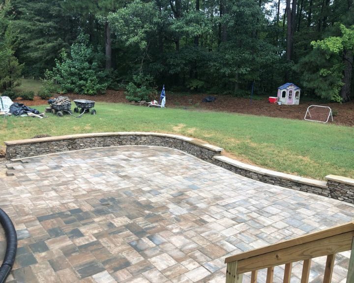 Backyard patio with stone pavers and play area.