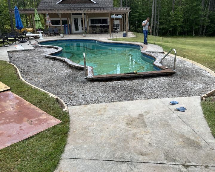 Backyard pool construction with surrounding patio area.