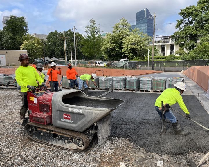 Construction workers laying concrete on site.