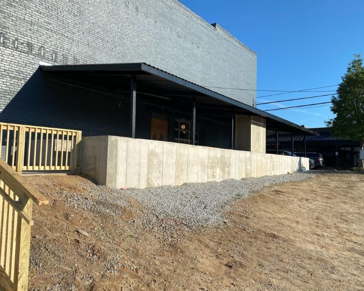 Industrial building with loading dock and gravel.