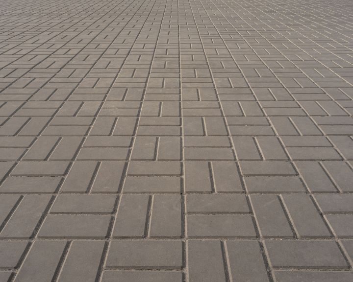 A sidewalk paved with concrete bricks.