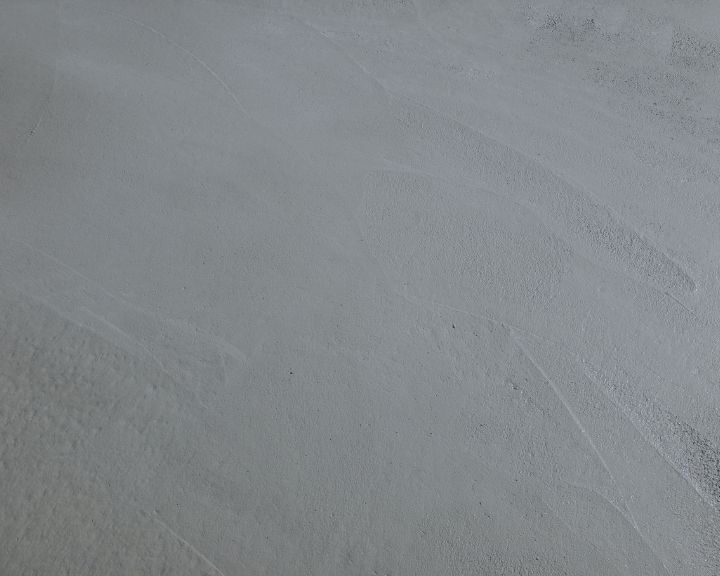 A close up of a concrete floor with white paint on it.