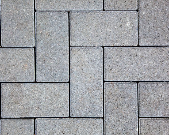 A close up image of a gray concrete paver in the city.